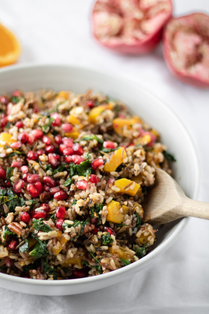 close up of harvest wild rice salad with a wooden serving spoon