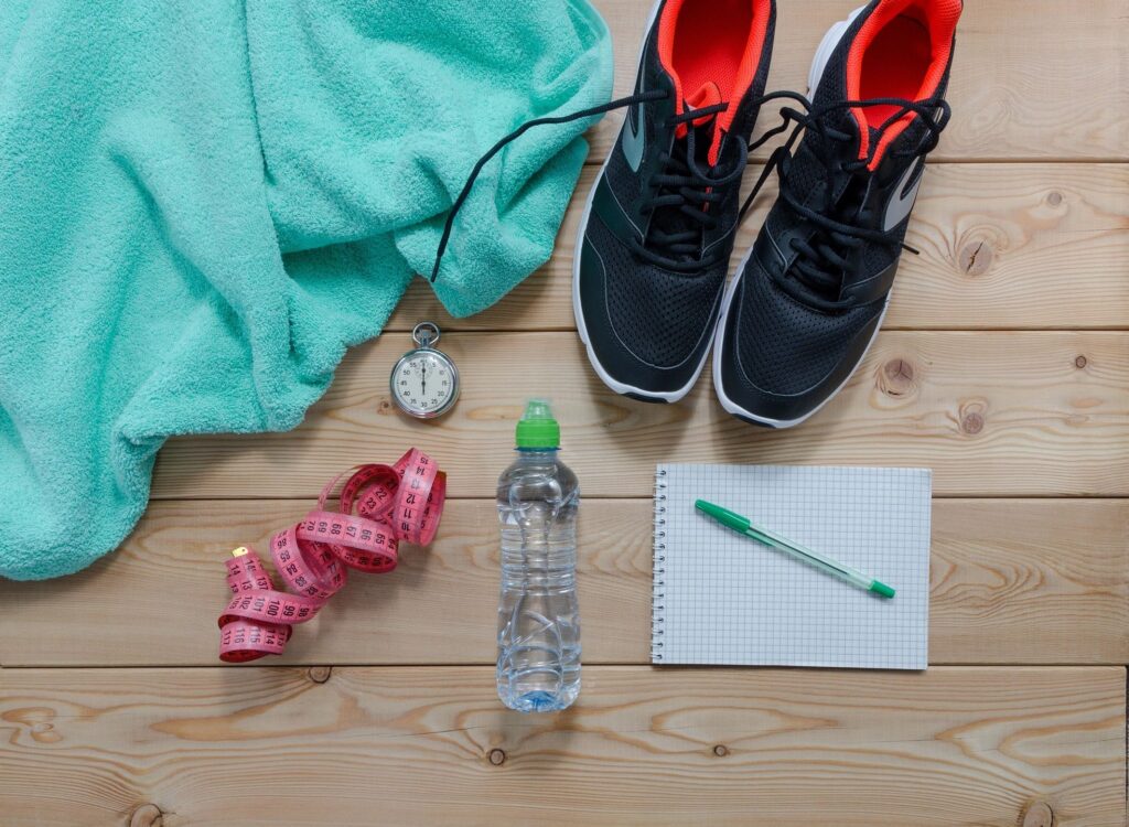 sneakers, water bottle, tape measure, towel, pen and paper