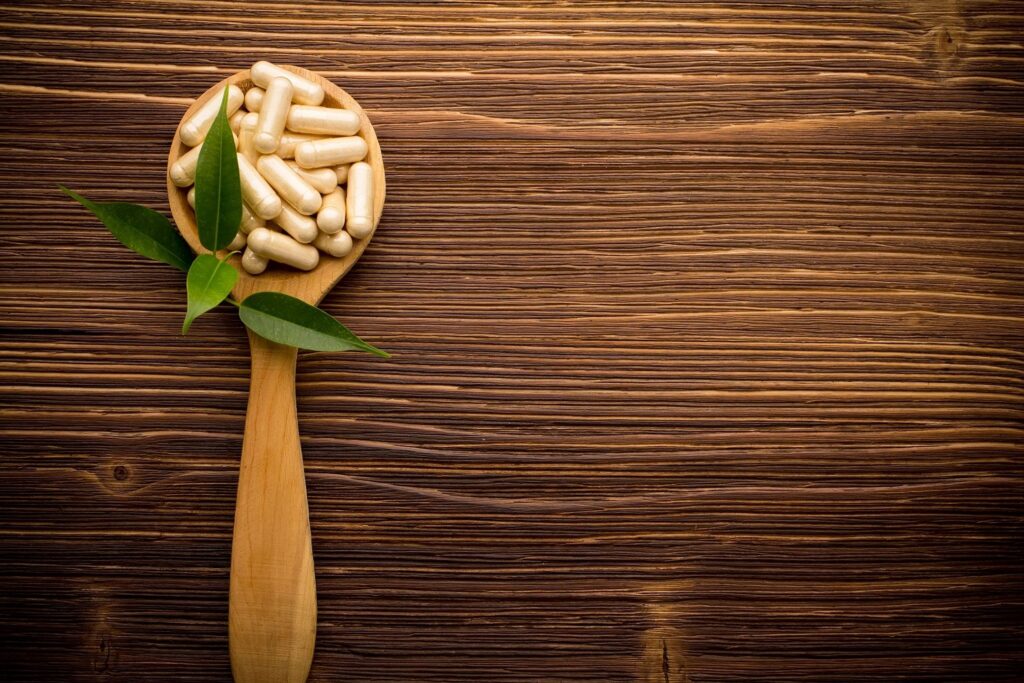 wooden spoon with vitamin capsules